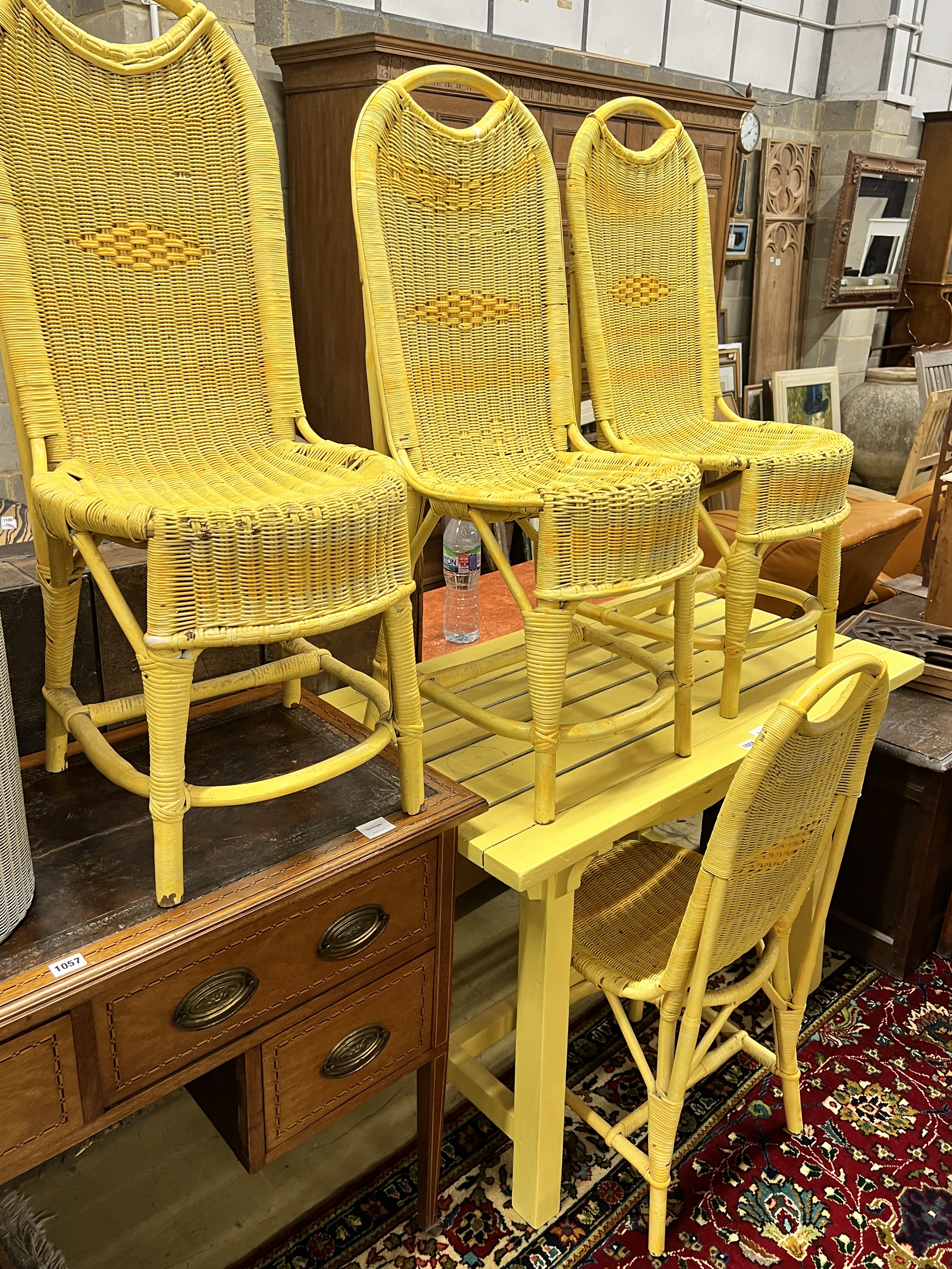A yellow painted slatted wood rectangular garden table, length 107cm, depth 61cm, height 74cm, four painted Lloyd Loom chairs and a laundry basket